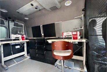 A second view of the van interior, with machines and a work chair